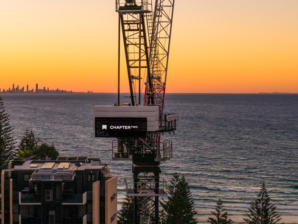 Tower crane silhouetted at dawn over the coast at Rainbow Bay