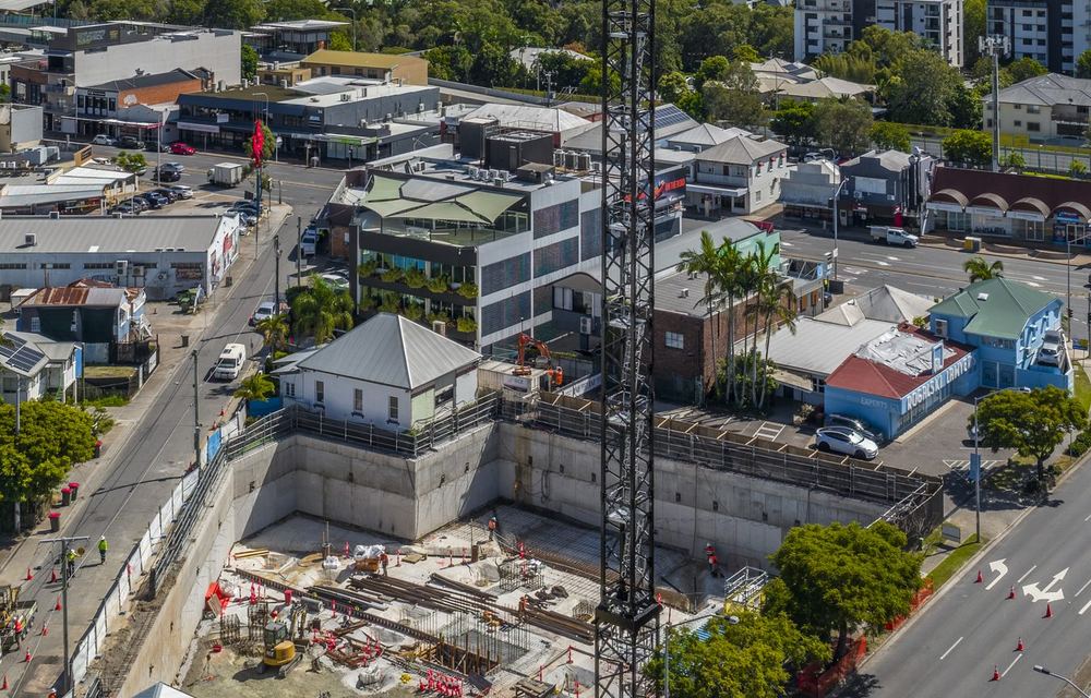 Crew working in the basement excavation beneath a tower crane at Stones Corner