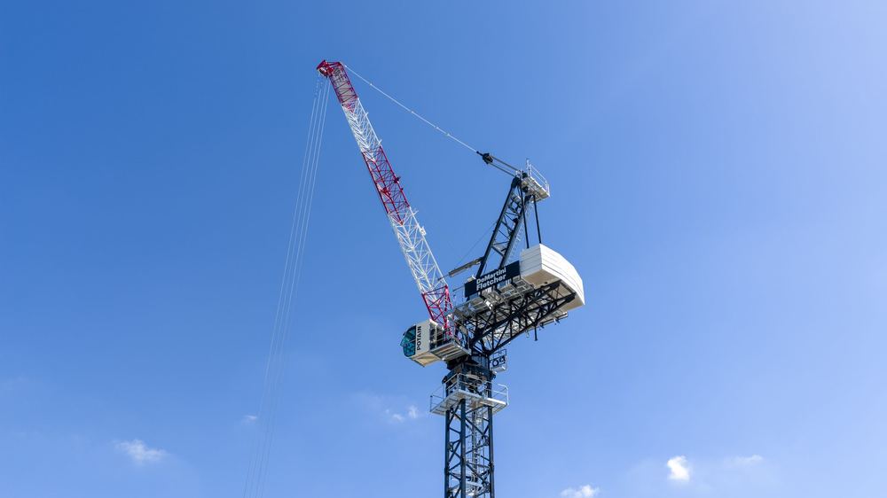 Looking straight up a tower crane's jib against a clear sky at Stones Corner