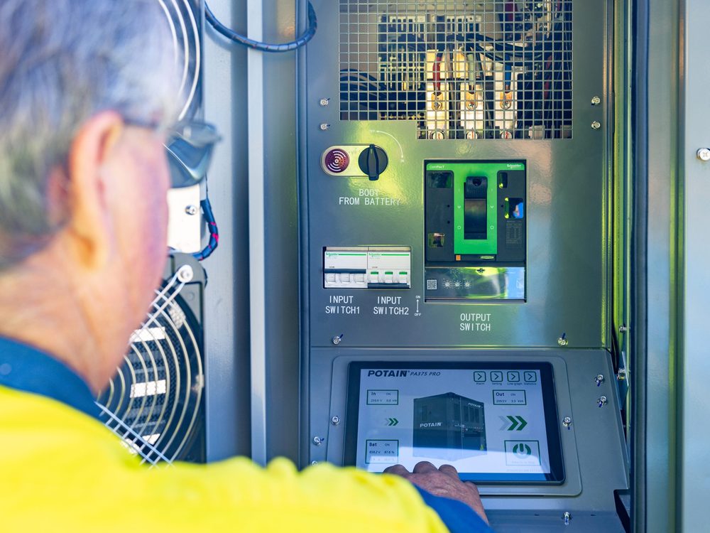 Technician at an open control cabinet in the TES yard